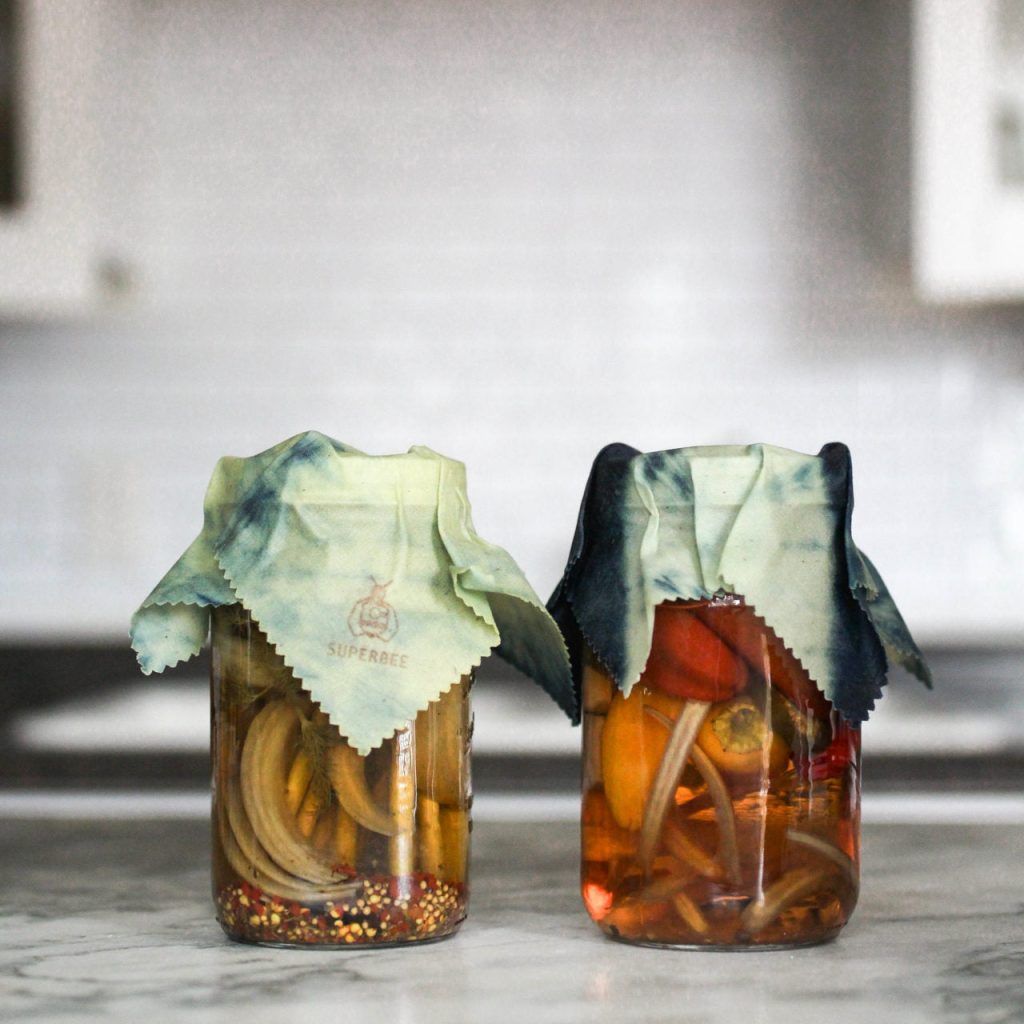 Pantry shelf with glass jars filled with grains and dry goods to reduce plastic waste